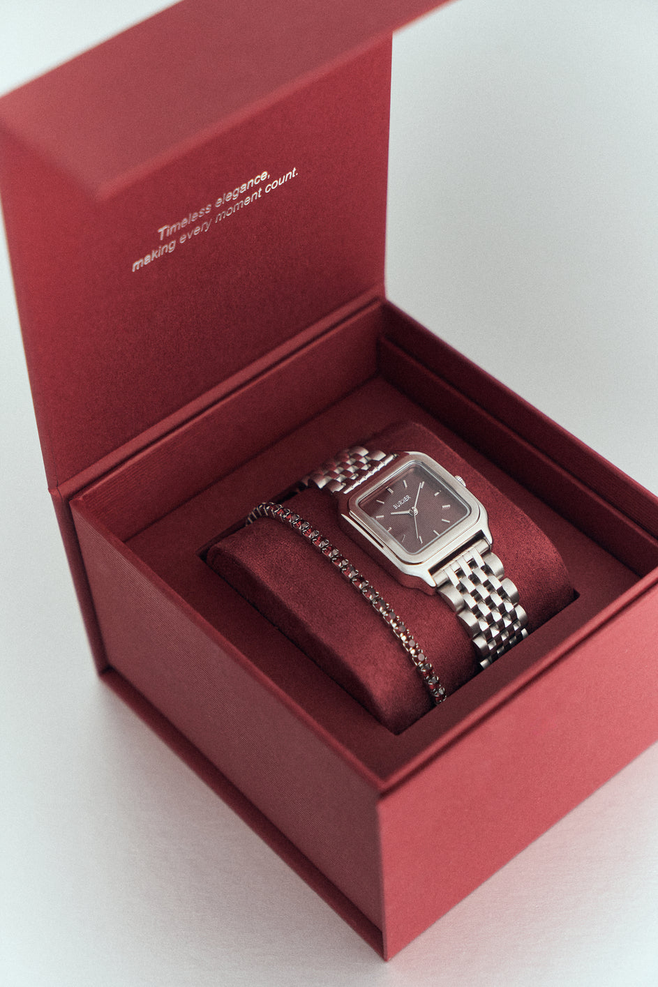 Silver-tone BURKER watch with a burgundy dial and a bracelet in a burgundy presentation box.
